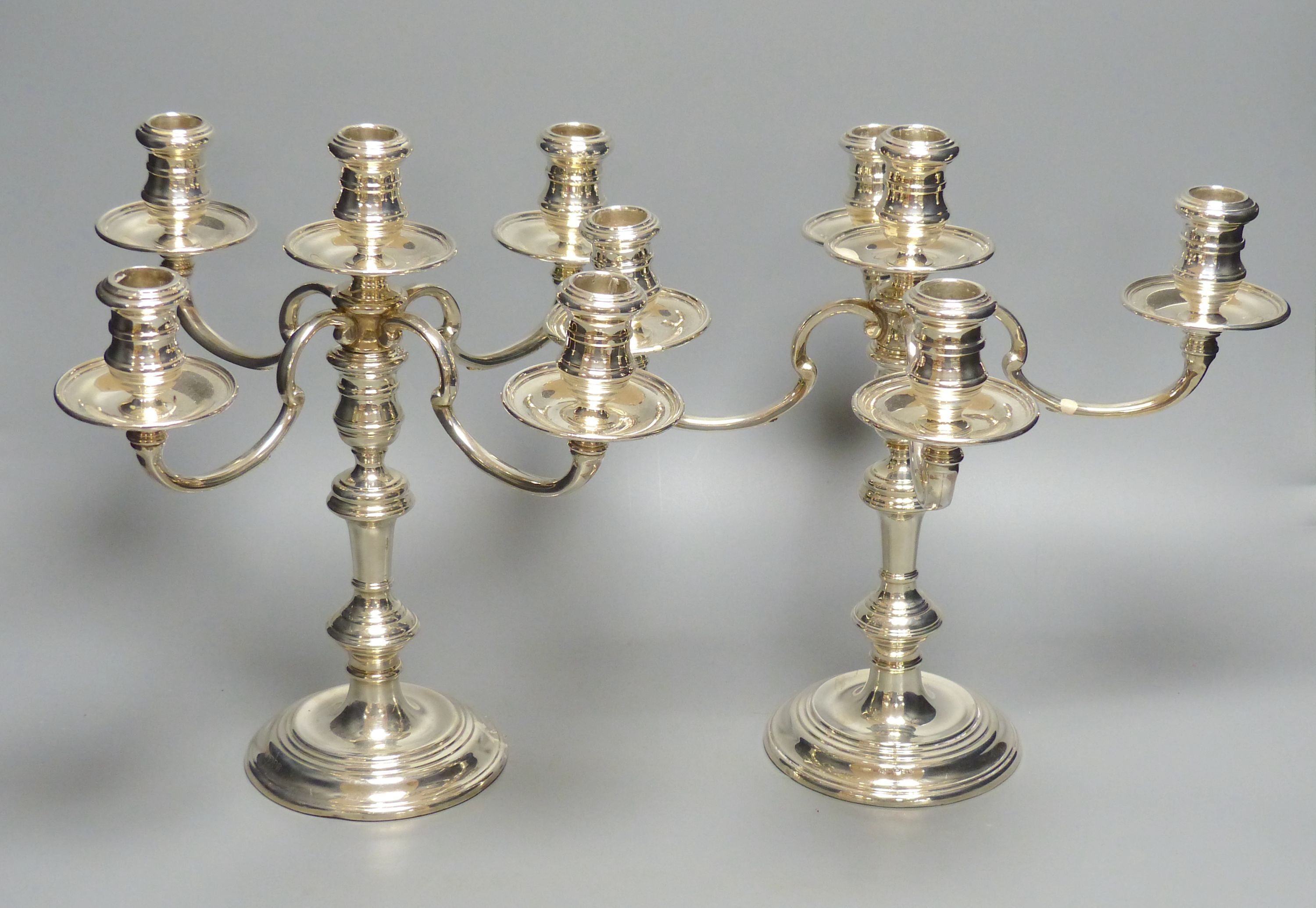 A pair of Georgian style silver four-branch five-light candelabra,